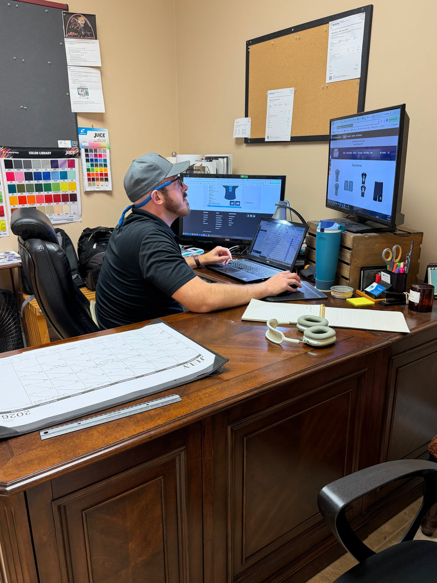 Custom team uniform proof being reviewed on screen with fabric color charts