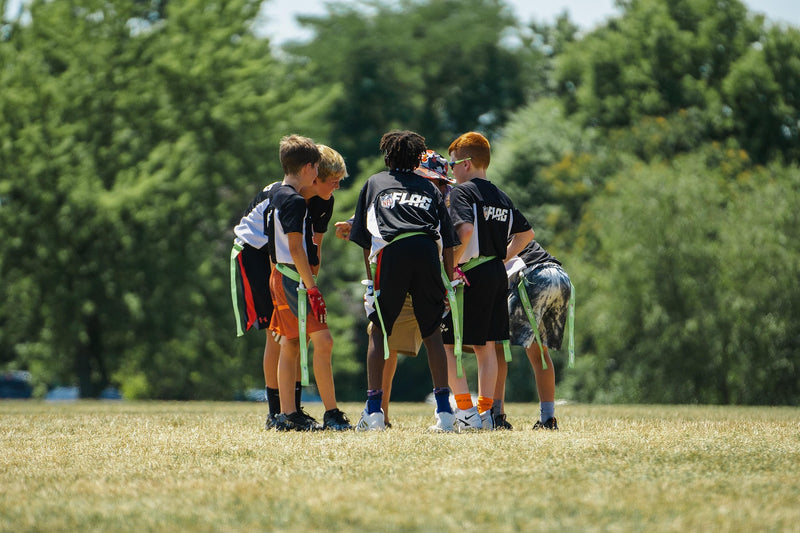 Flag football team huddled together on the field